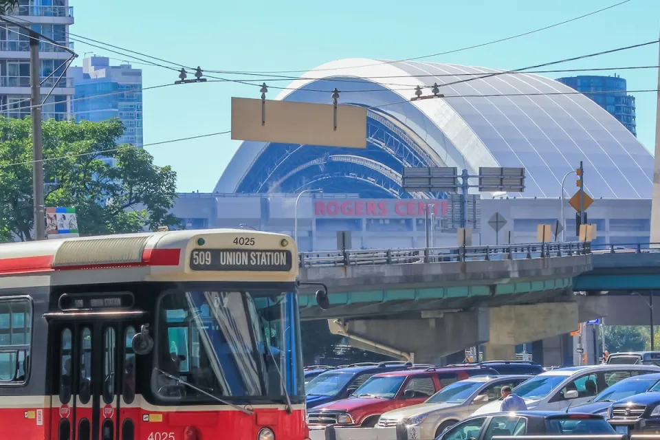 Vintage red Toronto streetcar passing in front of Rogers Arena in Toronto, Canada.